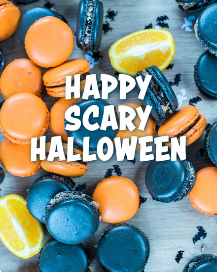 Orange and black macarons with 'Happy Scary Halloween' text