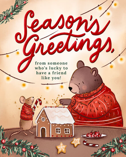 Bear and mouse in sweaters building gingerbread house with festive lights.