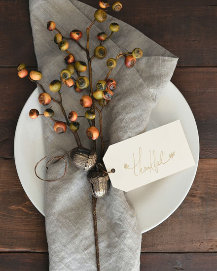 Thankful tag with berries and acorns on a napkin.